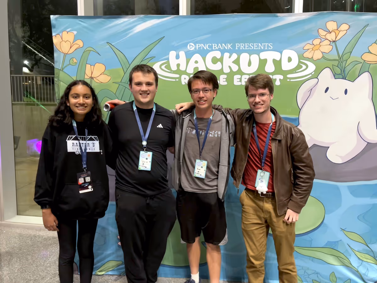 my team poses in front of a HackUTD banner