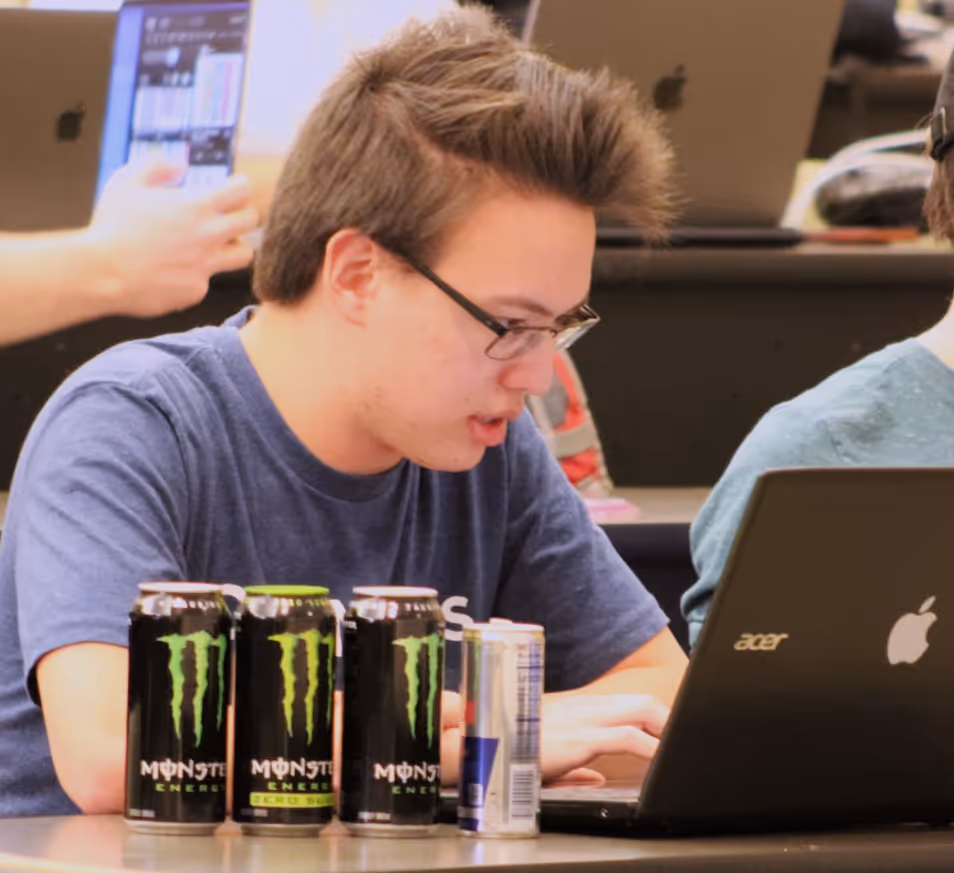 I code on my laptop behind a row of 3 Monsters and a Red Bull.